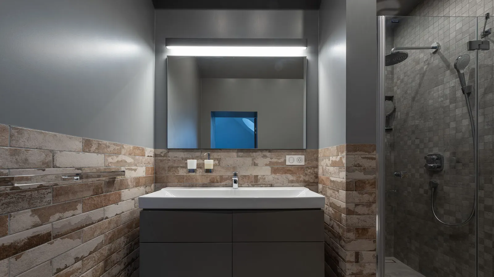 Bathroom vanity with a single-handle faucet above a rectangular sink.