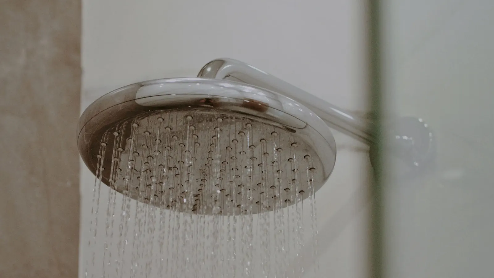 Water running from a round chrome-colored showerhead.