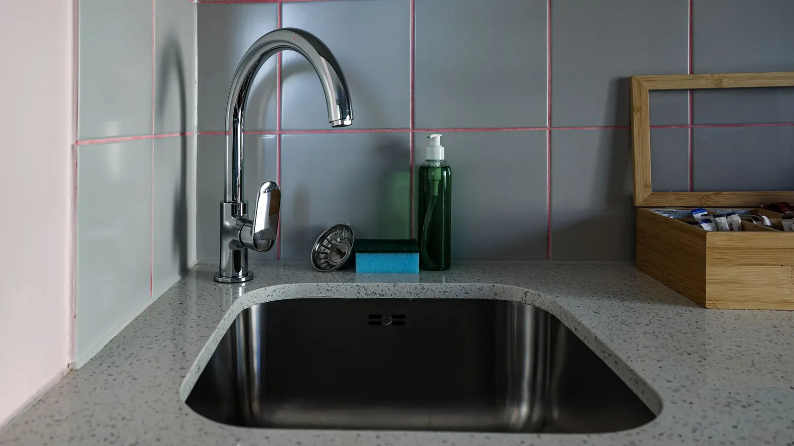 Stylish kitchen sink setup featuring chrome faucet, countertop, and accessories.