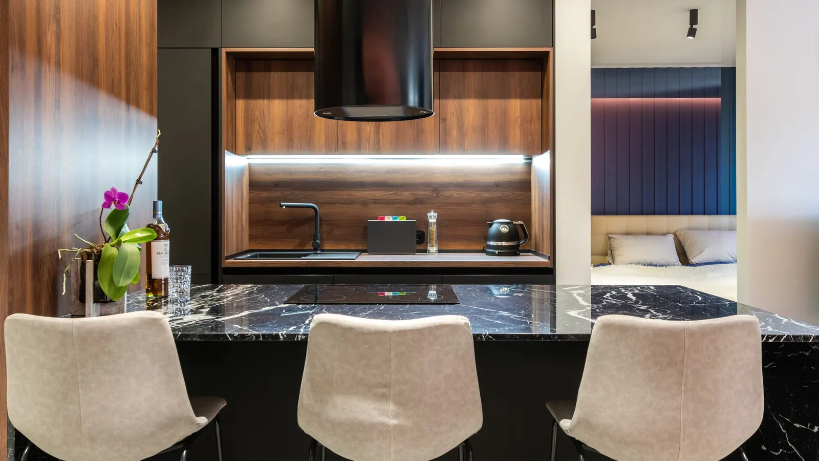 Modern kitchen with a black glass cooktop beneath a range hood.