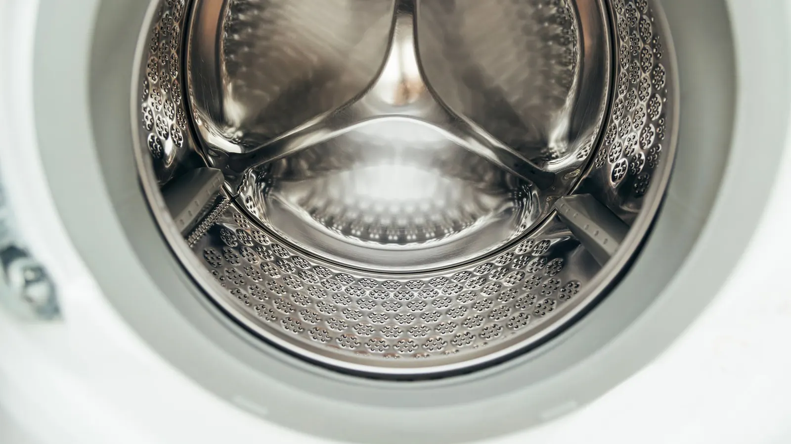 Close view into the metal drum and rubber door seal of a front-load washer.